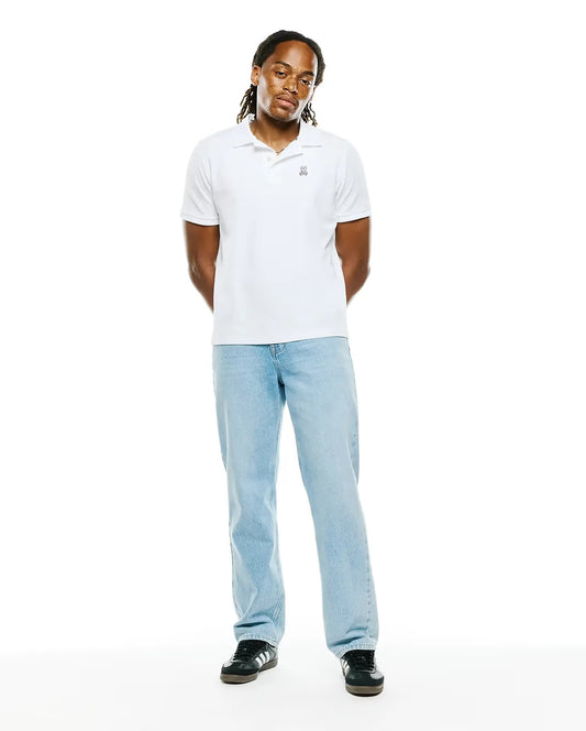 Model wearing Psycho Bunny men’s Classic Piqué Polo in 100 White