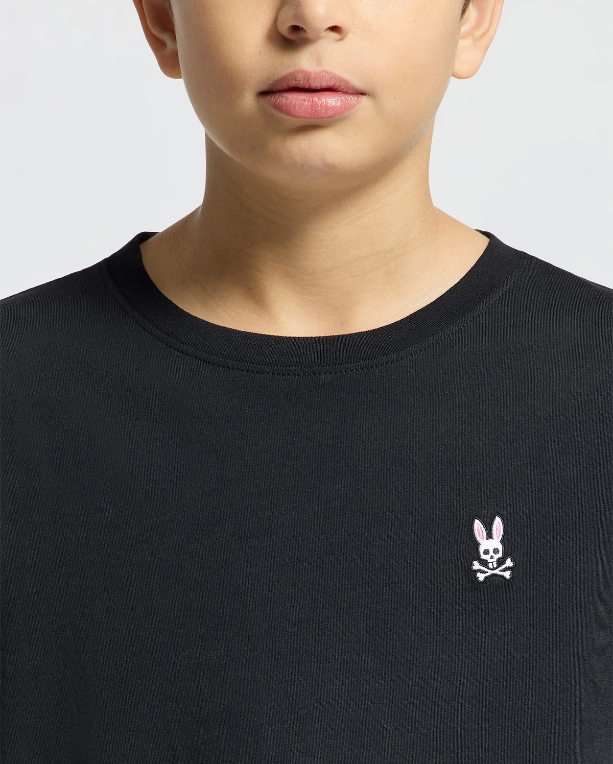 Close-up of Psycho Bunny Kids black T-shirt neckline and embroidered logo