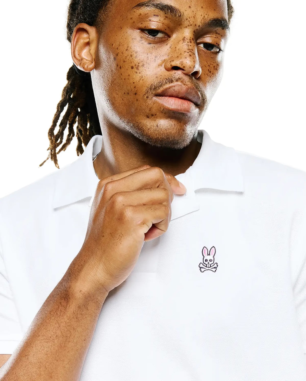 Close-up of Psycho Bunny white piqué polo collar and embroidered logo