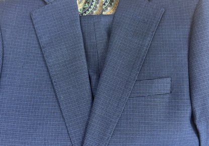 Blue checkered suit jacket with a patterned shirt collar on a wooden surface