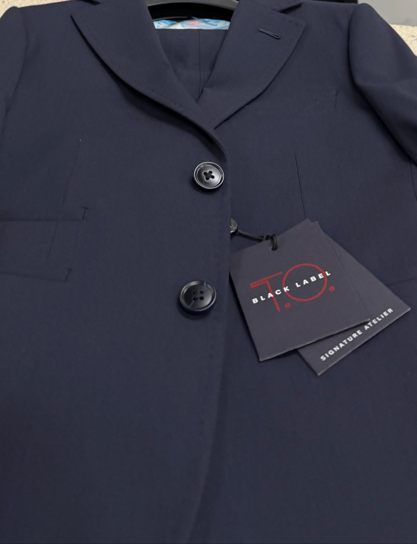 Navy coat with a tag on a white surface